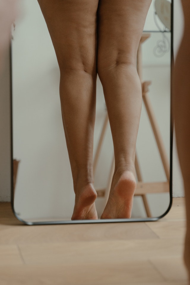 woman's legs standing in front of mirror