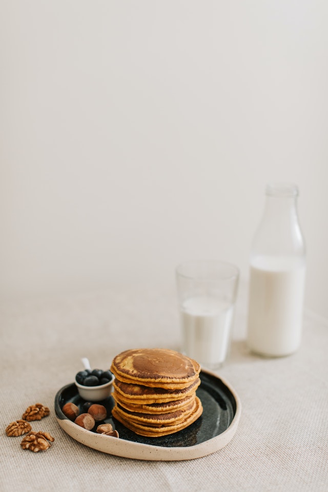 stack of pumpkin spice on a plate next to glass of milk